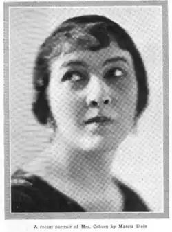 A woman with short dark hair and severe expression