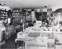 Black and white image showing an interior view of the Uptown Hardware Store.