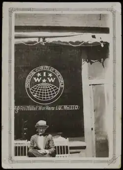 A man sits in front of the windows of the IWW offices in Yakima, Washington.